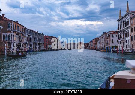 Wunderschöne Wasserstraße, die von einem Boot aus genommen wurde Taxi und farbenfrohe Häuser am Canale Grande in Venedig, Italien Stockfoto