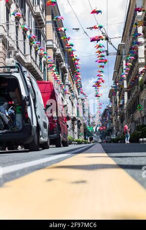 Niedrig positionierte Aufnahme von bunten, hellen Regenschirmen, die zwischen den Häusern entlang der Straße „XXV Aprile“ im Zentrum der Stadt Genua (Italien) hängen Stockfoto