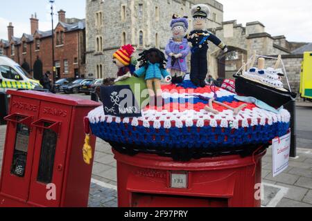 Windsor, Großbritannien. April 2021. Vor dem Schloss Windsor am Vorabend der Beerdigung von Prinz Philip ist ein von Ickenham Postbox Toppers hergerstellter, gestrickter Briefkastenaufschlag mit der Queen und dem Duke of Edinburgh, der königlichen Yacht Britannia und einigen Duke of Edinburgh Award-Studenten zu sehen. Kredit: Mark Kerrison/Alamy Live Nachrichten Stockfoto