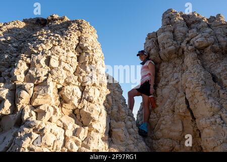 In Badlands Hoodoos schleicht sich die Frau im Sommer in die Spalte Stockfoto