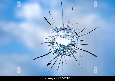 Risse im Fensterglas auf dem Hintergrund des Himmels. Stockfoto