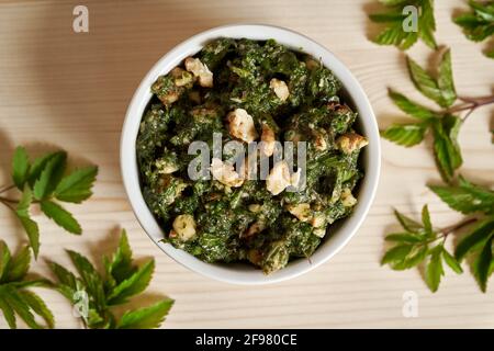 Pesto aus jungen gemahlenen Holunderblättern in einer Schüssel, Draufsicht Stockfoto