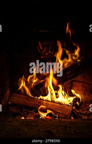 Brennholz in der Kamin-Nahaufnahme, glühende Protokolle, Feuer und Flammen brennen Stockfoto