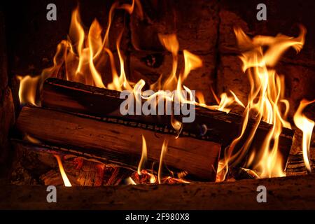 Brennholz in der Kamin-Nahaufnahme, glühende Protokolle, Feuer und Flammen brennen Stockfoto