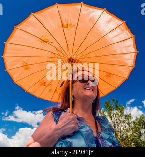 Outdoor Portrait Frau mit einem orange Sonnenschirm, kleinen Berg Stadt von Buena Vista, Colorado, USA Stockfoto