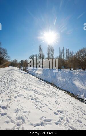 Bochum, Nordrhein-Westfalen, Deutschland - sonnige Winterlandschaft im Ruhrgebiet, Eis und Schnee beim renaturierten Hofsteder Bach, der Bach wurde in einen natürlichen Wasserkörper verwandelt, der Hofsteder Bach fließt über den Hüller Bach in den Emscher, Gehört zum Emscher-Flusssystem und damit zum Emscher-Umbau, war zuvor ein offener oberirdisch-oberirdisch-Abwasserkanal, Mischwasserkanal mit Oberflächenwasser und Abwasser. Stockfoto