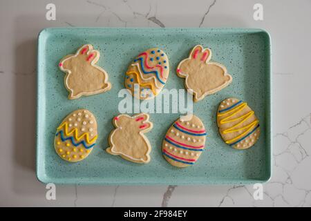 Tablett mit dekorierten Osterkeksen auf der weißen Theke, von oben geschossen. Stockfoto