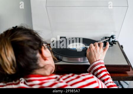 Von oben Frau, die eine CD in eine Stereoanlage einlegt Stockfoto