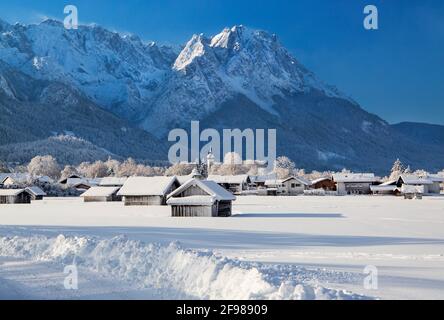 Winterlandschaft mit Heuscheunen gegen Waxenstein (2277m) in der Zugsptzgruppe (2962m), Garmisch-Partenkirchen, Wettersteingebirge, Werdenfelser Land, Oberbayern, Bayern, Deutschland Stockfoto