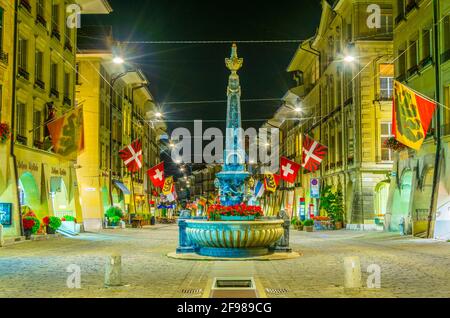 Nachtansicht des Kreuzgassbrunnens in der Kramgasse - der Hauptstraße in Bern, Schweiz Stockfoto