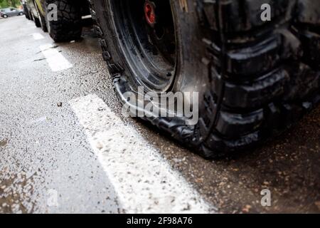 Reifen mit einem Reifenschaden in einem 4x4-Fahrzeug, der auf einer Stadtstraße geparkt wurde. Stockfoto