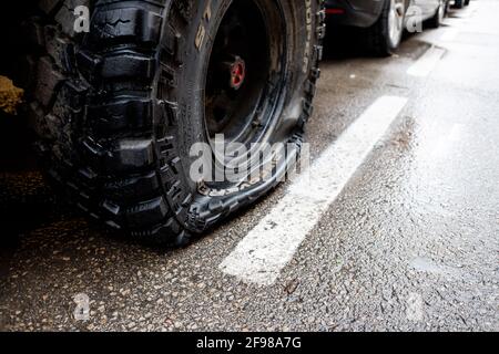 Valencia, Spanien - 15. April 2021: Reifenpanne eines Offroad-Autos, der auf einer Straße geparkt ist. Stockfoto