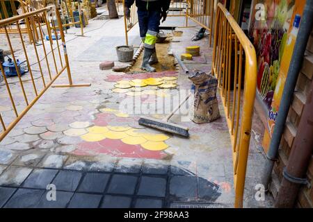 Valencia, Spanien - 15. April 2021: Arbeiter reparieren den Gehweg eines Fußgängerwegs in der Stadt. Stockfoto