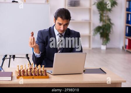 Junge Geschäftsmann Mitarbeiter spielen Schach am Arbeitsplatz Stockfoto