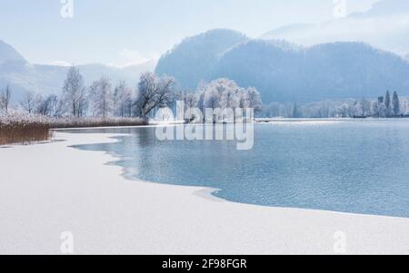 Ein magischer Wintermorgen in Schlehdorf am Kochelsee, Bayern, mit Frost, Sonnenschein, Nebel und frisch gefallener Schneedecke. Stockfoto