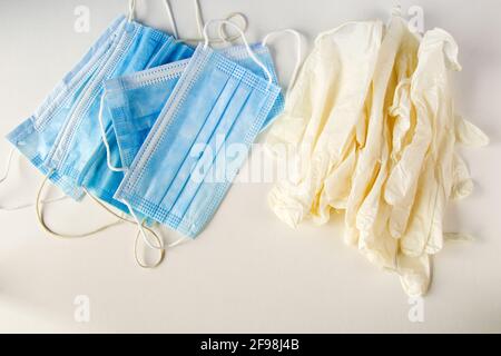 Draufsicht auf medizinische Handschuhe und Gesichtsmasken auf weiß Hintergrund Stockfoto