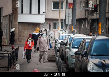 BELGRAD, SERBIEN - 14. FEBRUAR 2021: Selektive Verwaschung einer Mutter, einer Frau und ihrer Tochter, die mit Gesichtsmaske und Schutzausrüstung auf Cor in der Flucht ist Stockfoto