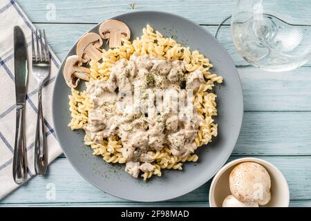 Tagliatelle Italienische Pasta mit Wald weißen Champignon Pilze cremige Sauce Und Huhn oder Rindfleisch - hausgemachte Speisen auf dem Teller Auf der Tischansicht Stockfoto