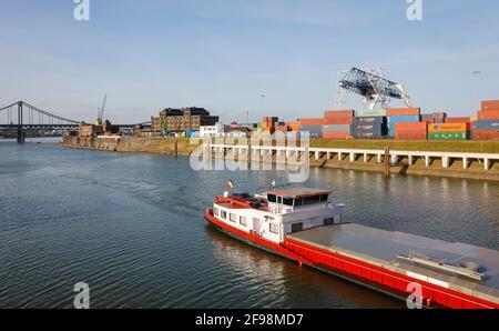 Krefeld, Nordrhein-Westfalen, Deutschland - der Rheinhafen Krefeld ist der viertgrößte Hafen in Nordrhein-Westfalen, ein Frachtschiff fährt am KCT Krefelder Container Terminal vorbei, hinter der Krefeld-Uerdinger Brücke über den Rhein. Stockfoto