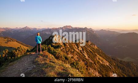 Der Mensch genießt den Sonnenuntergang in den Bergen bei Bad Hindelang. Allgäuer Alpen, Bayern, Deutschland Stockfoto