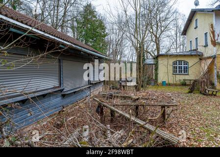 Lost Place, bewachsener Biergarten mit moosbedeckten Sitzbereichen, Gasthof Obermühltal, Bayern, Deutschland, Europa Stockfoto