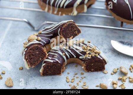 Nahaufnahme einer halbierten appetitlichen Schokolade überzogenen rohen Donuts mit Nüsse bestreuen Stockfoto