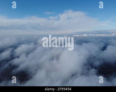 Hoch über dem dichten Nebel, wie ein wunderschönes Wolkenmeer bei Sonnenaufgang. Die Sonne geht über dem endlosen Wolkenmeer bis zum Horizont auf. Atemberaubende Natur Stockfoto