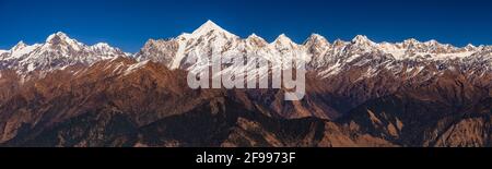 Panoramablick auf schneebedeckten Panchuli Gipfel fällt in großen Himalaya-Gebirge und alpine Graswiesen im kleinen Weiler Munsiyari, Kumaon reg Stockfoto