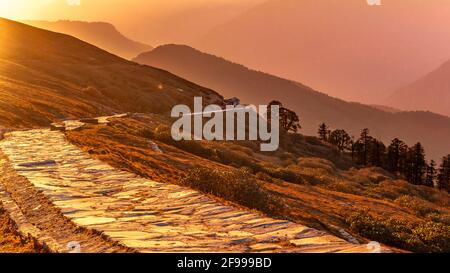 Blick vom steinernen gepflasterten Chandrashila Tungnath Wanderweg durch alpine Wiesen des Himalaya in Chopta, Uttarakhand. Garhwal Himalaya bietet immense Stockfoto