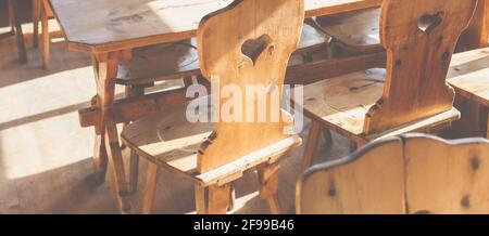 Rustikale Gemütlichkeit, Holzstühle - bayerisch, hautnah, mit Herz sitzen Stockfoto