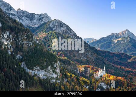 Schloss Neuschwanstein an einem sonnigen Herbsttag vor einer wilden Berglandschaft. Bayern, Deutschland, Europa Stockfoto