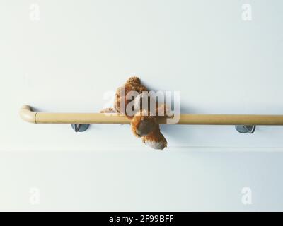 Ein vergessener, einsamer, einsamer Teddybär ist auf einer Armlehne im Krankenhaus gefangen. Stockfoto