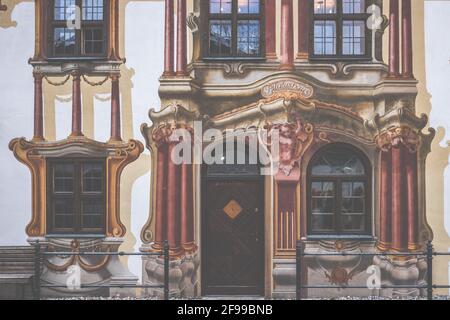 Dorfansichten - Wandmalerei, Fächermalerei oder Fassadenmalerei auf dem Pilatushaus in Oberammergau - Dorf unter dem Kofel Stockfoto