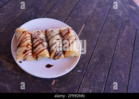 Draufsicht auf einen Teller gefüllter Pfannkuchen, der mit bedeckt ist Schokoladenglasur Stockfoto