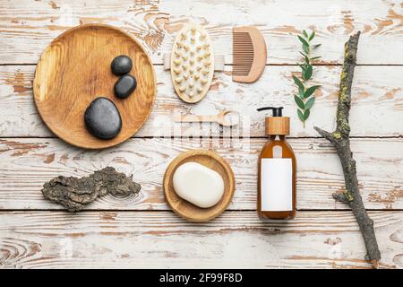 Flasche mit Naturshampoo, Pinsel und Seife auf Holzgrund Stockfoto