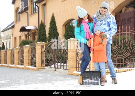 Die Familie entfernt Schnee im Freien am Wintertag Stockfoto