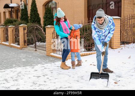 Die Familie entfernt Schnee im Freien am Wintertag Stockfoto