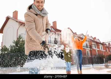 Die Familie entfernt Schnee im Freien am Wintertag Stockfoto