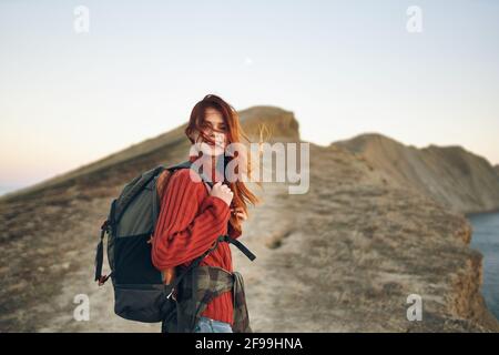 Die Touristenfrau steigt an der Spitze der Bar entlang Die Straße mit einem Rucksack auf dem Rücken Stockfoto