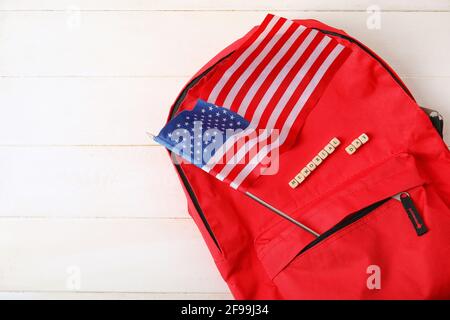 Text GEDENKTAG mit USA-Flagge und Rucksack auf weiß Holzhintergrund Stockfoto