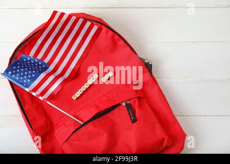 Text GEDENKTAG mit USA-Flagge und Rucksack auf weiß Holzhintergrund Stockfoto