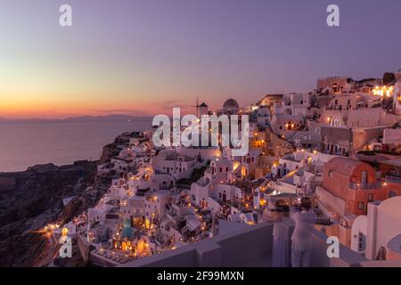 Atemberaubende Aussicht auf die Caldera bei Nacht, malerisches Dorf Oia mit traditionellen weißen Häusern unter Sonnenuntergang. Tolle Urlaubslandschaft Stockfoto