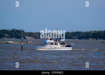 Helsinki / Finnland - 16. APRIL 2021: Ein weißes Freizeitboot, das im finnischen Archipel unterwegs ist. Stockfoto