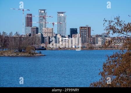 Helsinki / Finnland - 16. APRIL 2021: Modernes Wohnviertel wird gebaut. Drei Wolkenkratzer im Hintergrund. Stockfoto
