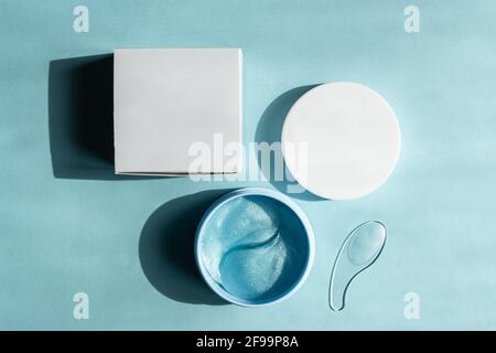 Hyaluronic Skin Patch Maske zur Reduzierung von Schwellungen und Blutergüssen unter den Augen. Flatlay. Blick von oben auf blauem Hintergrund. Selbstpflege und Spa Conce Stockfoto