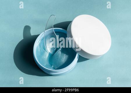 Hyaluronic Skin Patch Maske zur Reduzierung von Schwellungen und Blutergüssen unter den Augen. Flatlay. Blick von oben auf blauem Hintergrund. Selbstpflege und Spa Conce Stockfoto