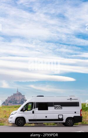 Wohnmobil / Van 'Vantourer Black and White' vor der schönen historischen Gezeiteninsel und Festung Le Mont-Saint-Michel. Das Denkmal ist ein UNESCO-Weltkulturerbe in der Normandie, Frankreich Stockfoto