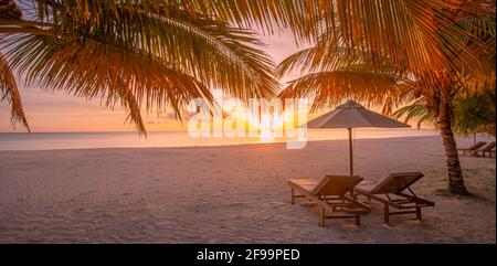 Atemberaubende Strandszene bei Sonnenuntergang. Liegen am Sandstrand in der Nähe des Meeres. Sommerurlaub und Urlaubskonzept Tourismus. Inspirierende tropische Landschaft Stockfoto