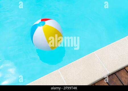 Farbenfroher Beach Ball schwimmt auf einem Swimmingpool. Speicherplatz kopieren Stockfoto