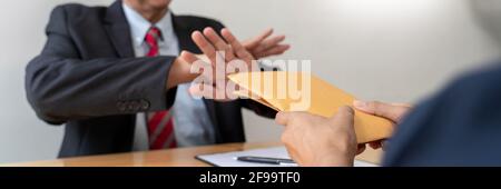 Selbstbewusster Manager eines Geschäftsmannes, der ein Angebot von Geld zur Vereinbarung eines Vertrags vom Partner ablehnt oder das Konzept von Bestechung, Bestechung und Korruption ablehnt Stockfoto
